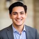 Chris T. in a graduation portrait wearing smart casual clothes and a confident smile